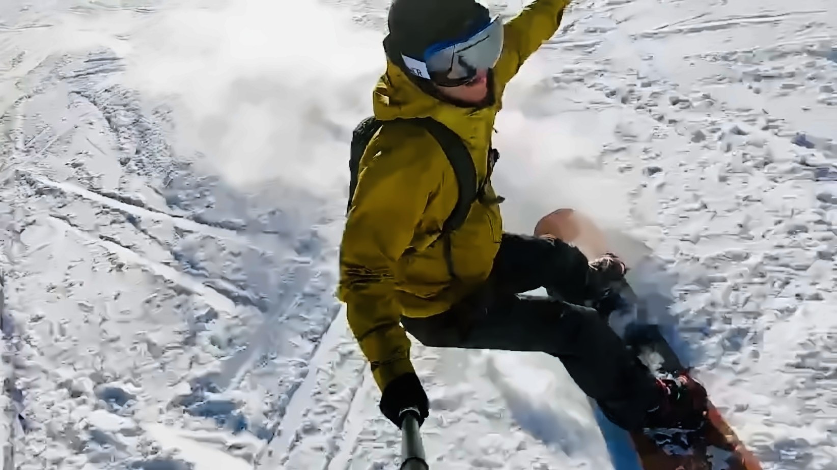 Snowboarding down a mountain, filmed on a pole camera